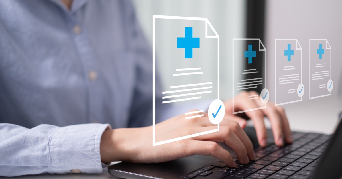 A healthcare professional types on a laptop with digital medical certification forms and blue checkmarks overlay on the screen.